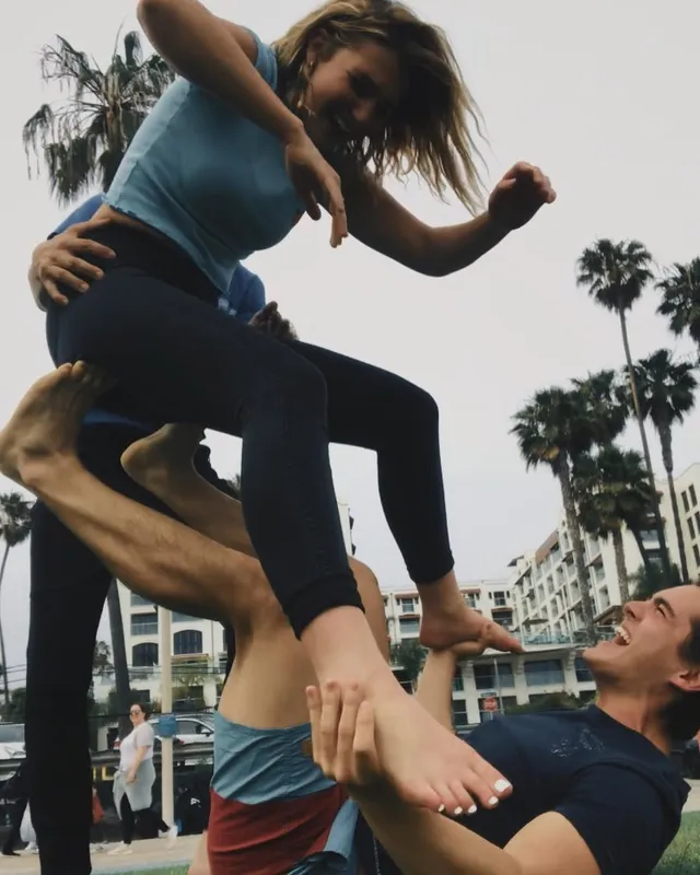 Sophie Nélisse being lifted barefoot by friends outdoors.