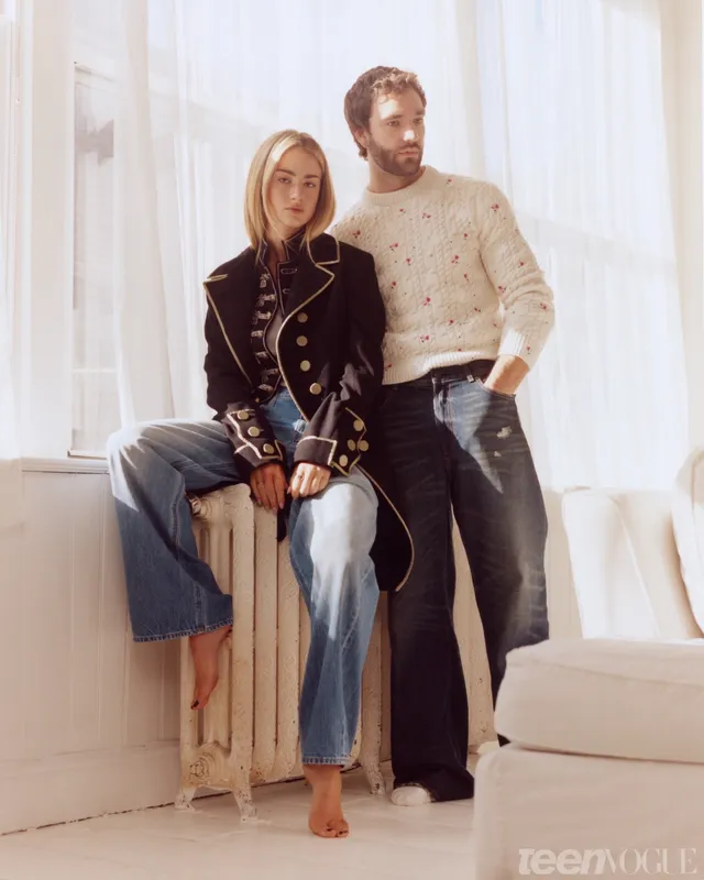 Grace Van Patten posing barefoot beside a man in a bright studio.