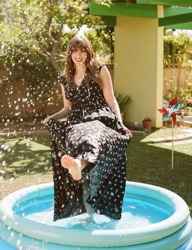 Elizabeth Olsen playing barefoot in a small paddling pool.