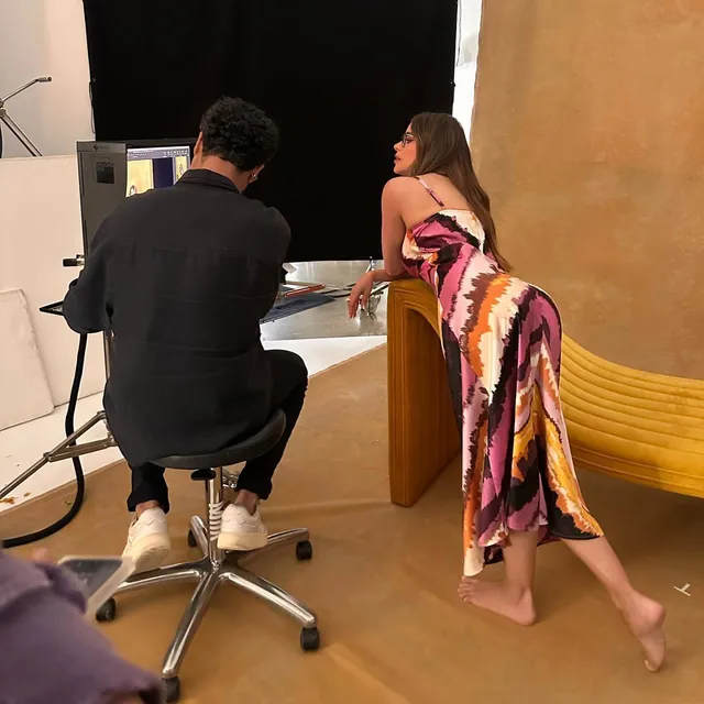 Sofía Vergara leaning beside a counter during a photo shoot with a bare sole visible.