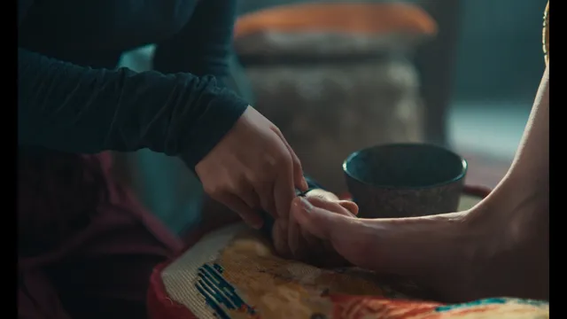 Eva Green a close screen detail with bare feet beside a bowl.