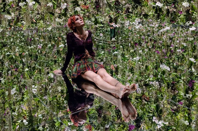 Halsey a relaxed barefoot portrait among flowers.