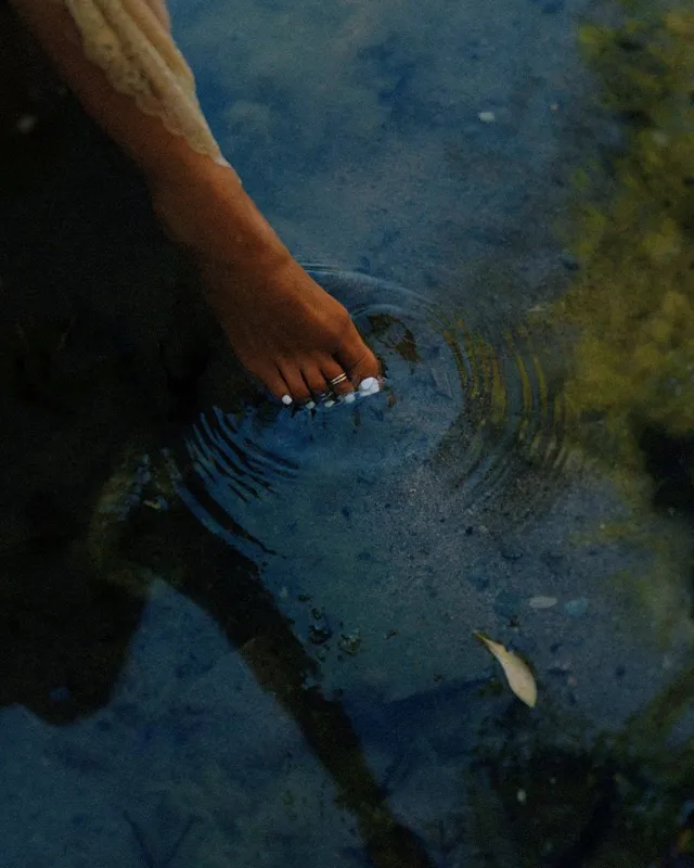 Megan Fox dipping her toes into a pool in a close-up.