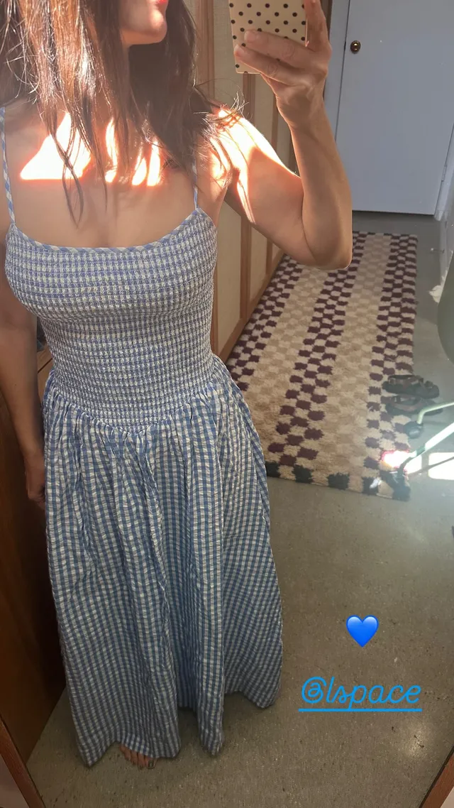 Rachel Bilson taking a mirror portrait in a checked outfit.