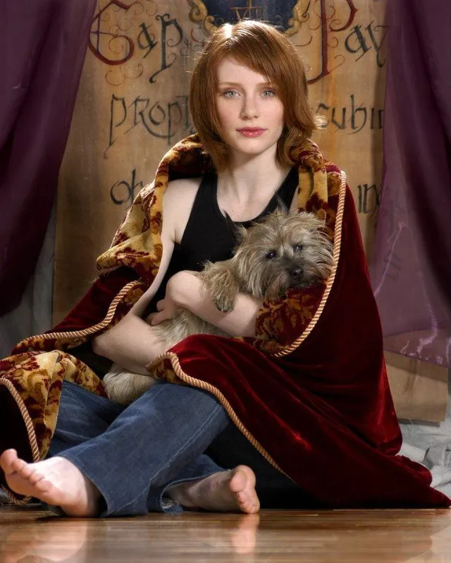 Bryce Dallas Howard sitting on the floor beside a dog.