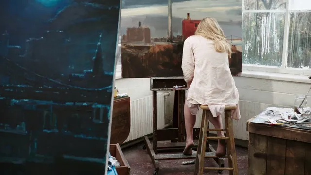 Natalie Dormer turning on a studio stool in a pale outfit.