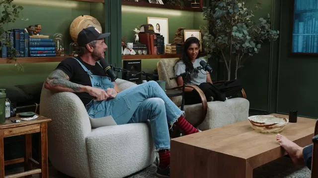 Gal Gadot sitting barefoot with a group in a living room.