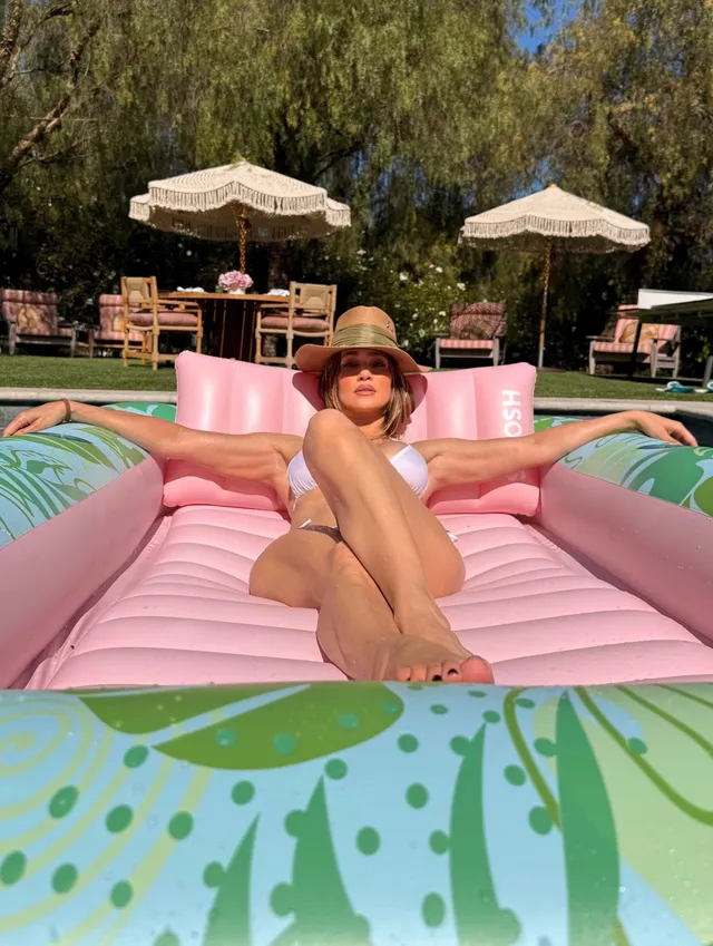 Jennifer Lopez relaxing on a pink swimming-pool float.