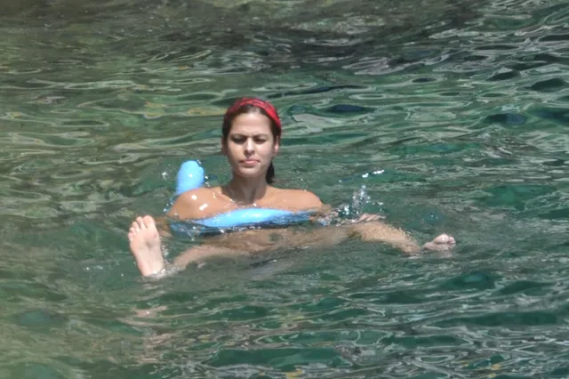 Eva Mendes swimming in clear green water.