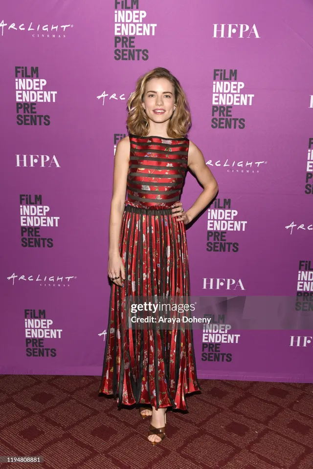 Willa Fitzgerald posing in a red patterned gown and heels.