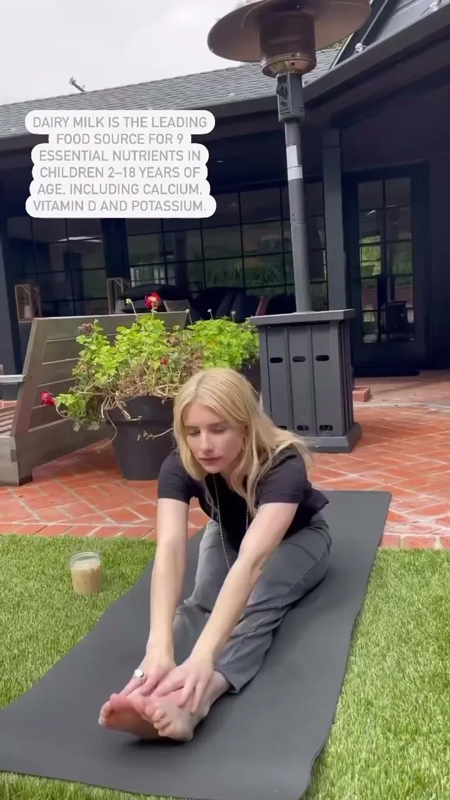 Emma Roberts stretching on a mat with bare soles facing the camera.