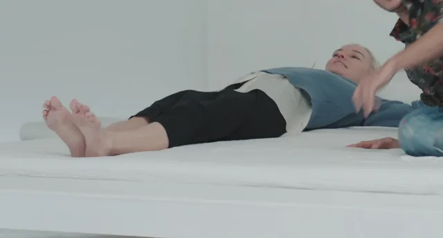 Kate Bosworth lying on a bed with another performer nearby.