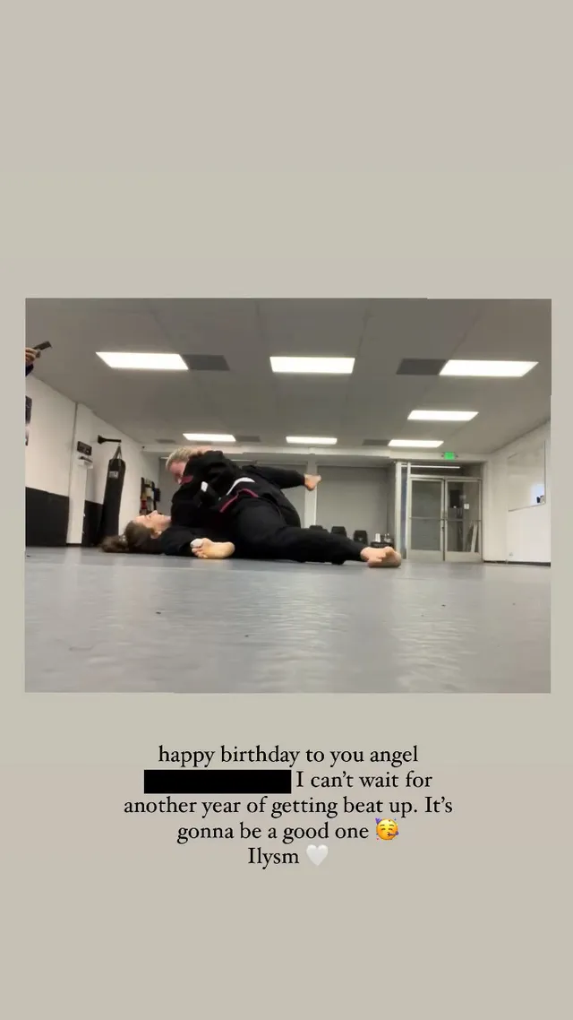 Chloë Grace Moretz training barefoot on a gym floor beside another person.