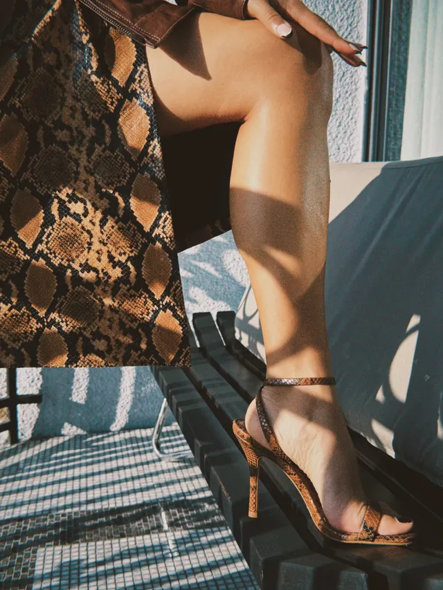 Kiana Madeira shown in a close-up wearing brown ankle-strap heels.