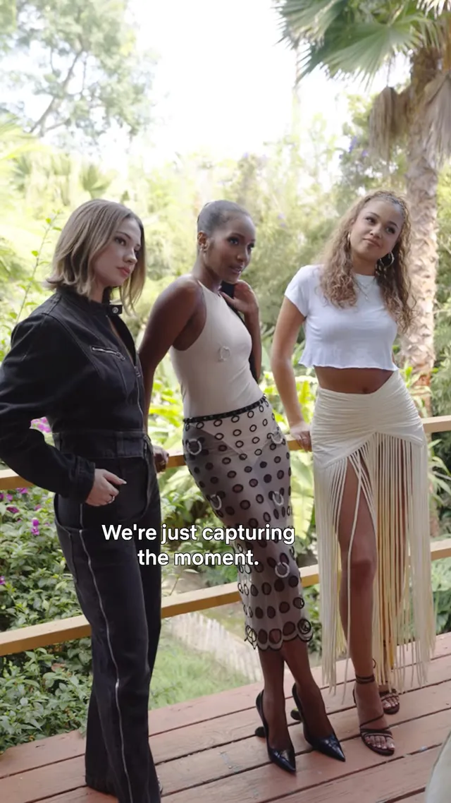 Madison Bailey standing with friends in a fringe skirt and heels.