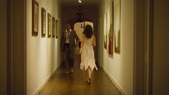 Odessa A'zion walking down a hallway barefoot in a scene.