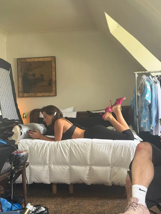 Adèle Exarchopoulos reclining on a bed in pink heels.