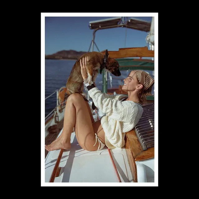 Emma Watson: reclining barefoot on a boat beneath a canopy.