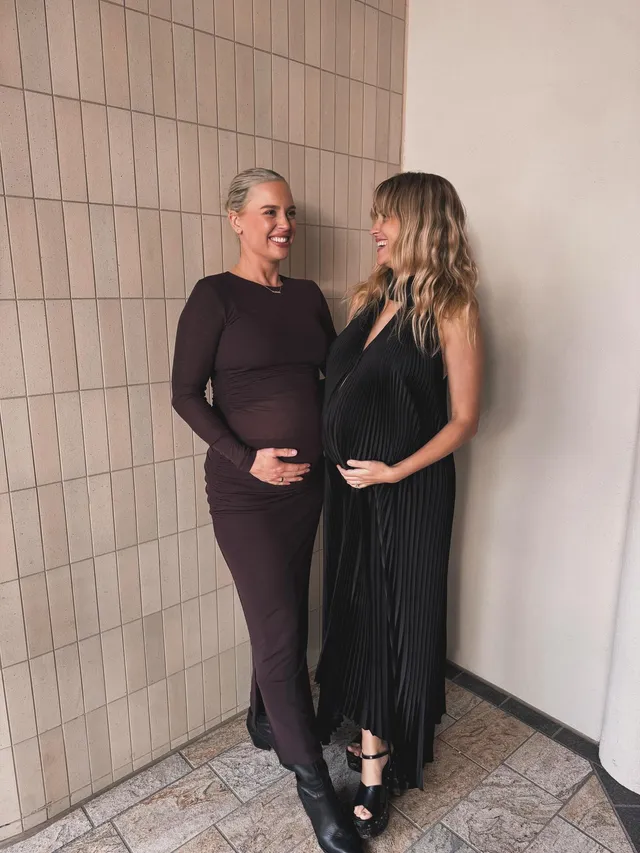 Teresa Palmer standing with a companion in a long black dress.