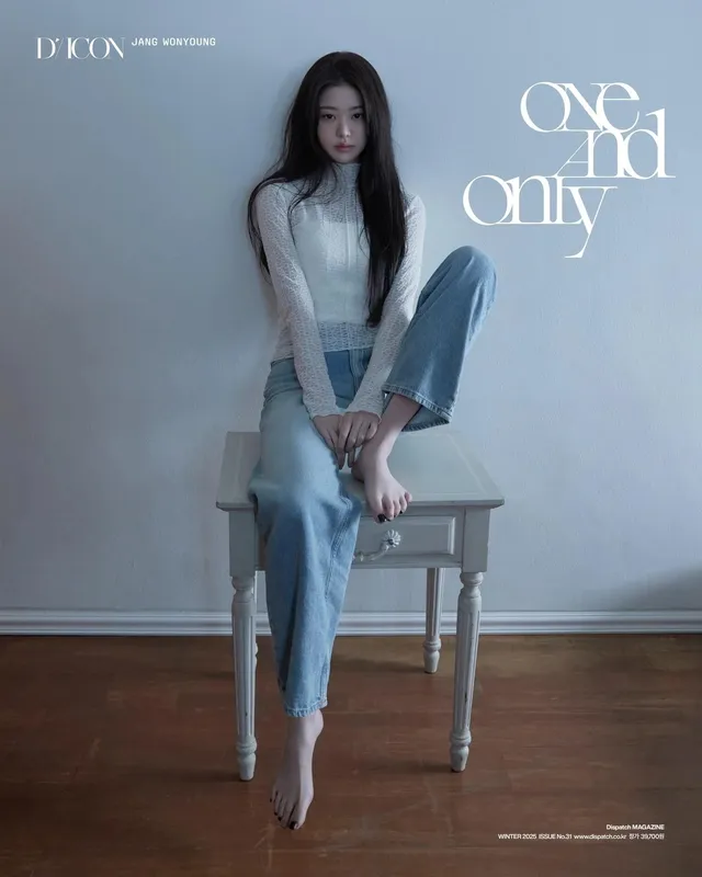 Jang Wonyoung sitting barefoot on a stool in jeans for a magazine portrait.