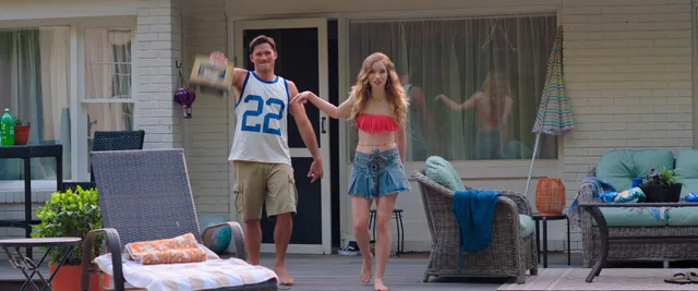 Willa Fitzgerald standing barefoot beside a pool in a scene.
