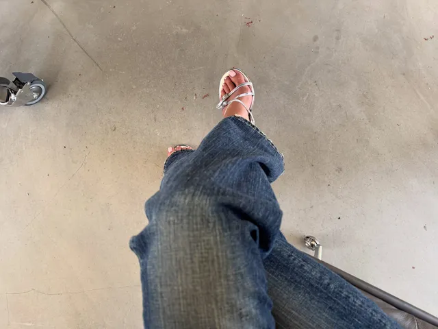 Kylie Jenner wearing strappy heels beneath jeans.