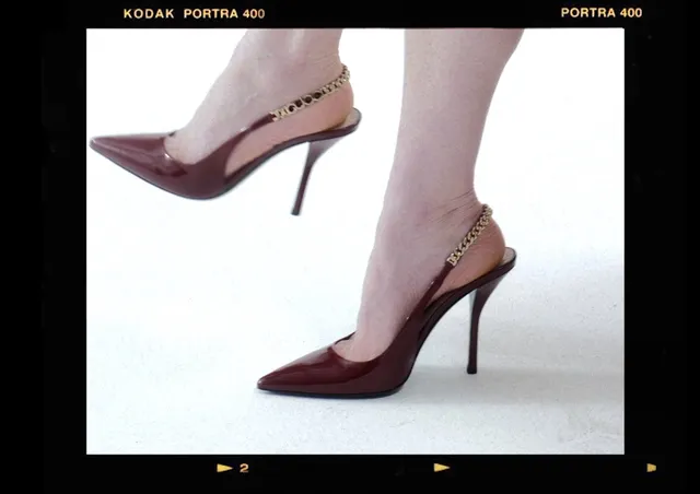 Kirsten Dunst wearing burgundy pointed high heels in a studio image.