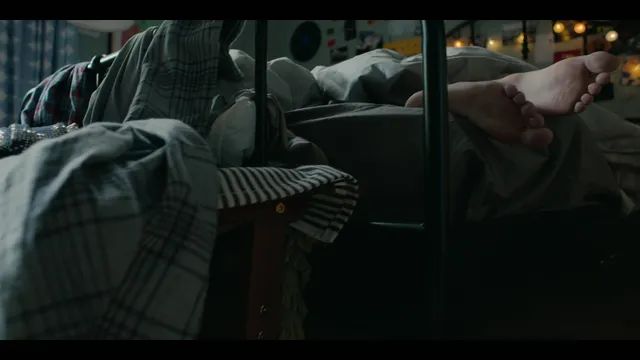 Nicole Wallace shown lying on a bed with bare feet raised in a screen capture.