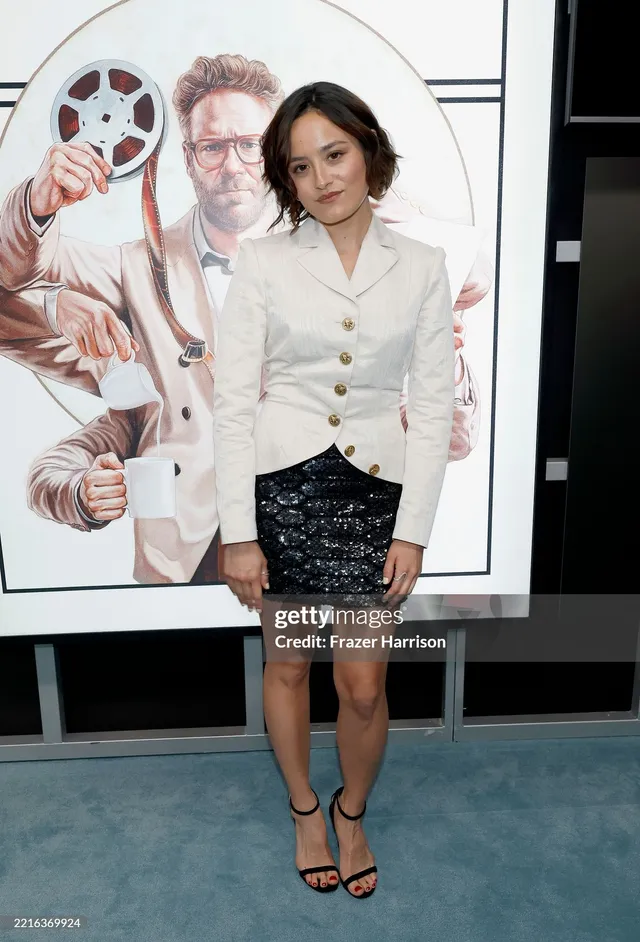 Chase Sui Wonders wearing a white jacket and black heels at an event.
