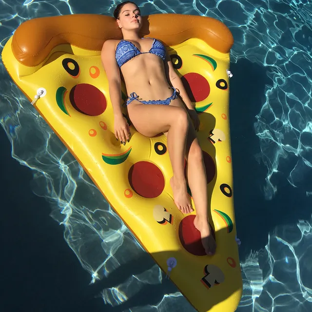 Ariel Winter relaxing on a pizza-shaped pool float.