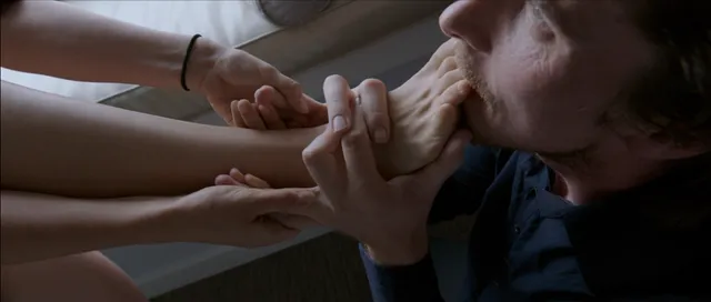 Natalie Portman appearing in a scene with a bare foot held beside her.