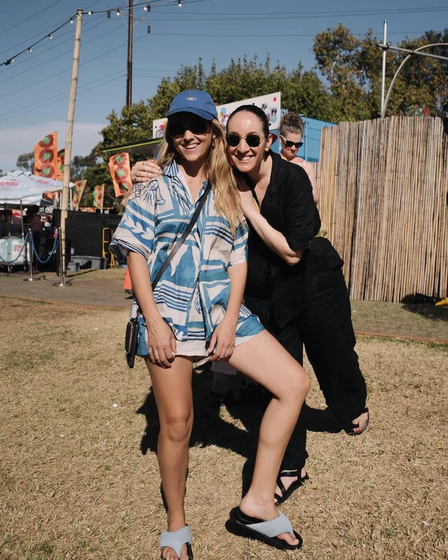 Teresa Palmer standing beside a companion at an outdoor gathering.