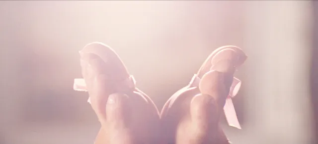 Sydney Sweeney with her bare feet raised in a softly lit close-up.
