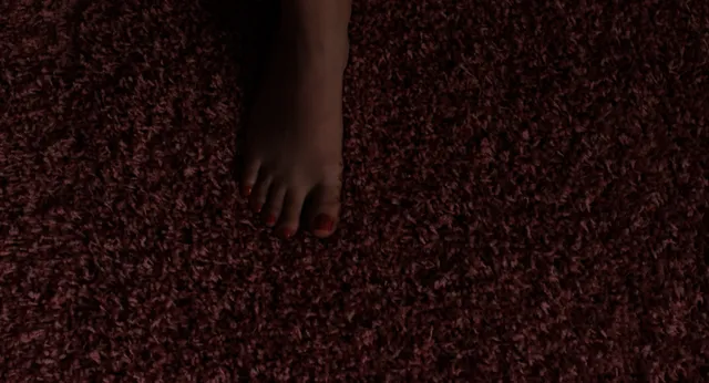 Cailee Spaeny showing a bare foot on a patterned carpet.
