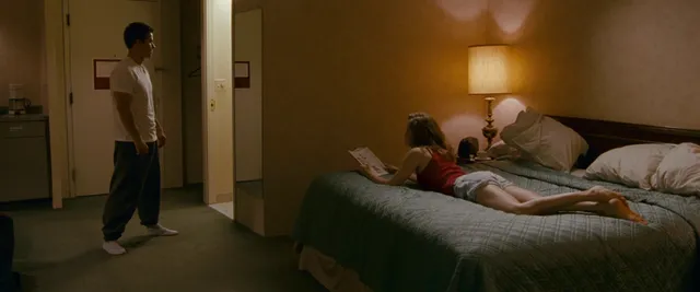 Amy Adams reclining on a bed during a screen scene.