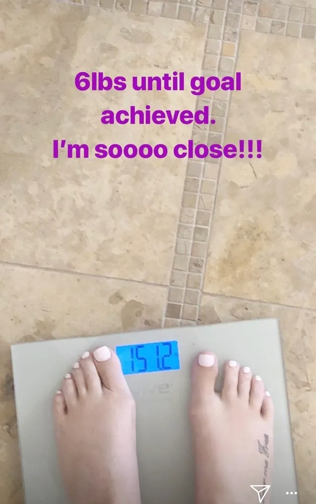 Iggy Azalea standing barefoot on bathroom scales.