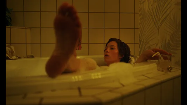 Jessica Biel a screen detail of a bare sole above a bathtub.