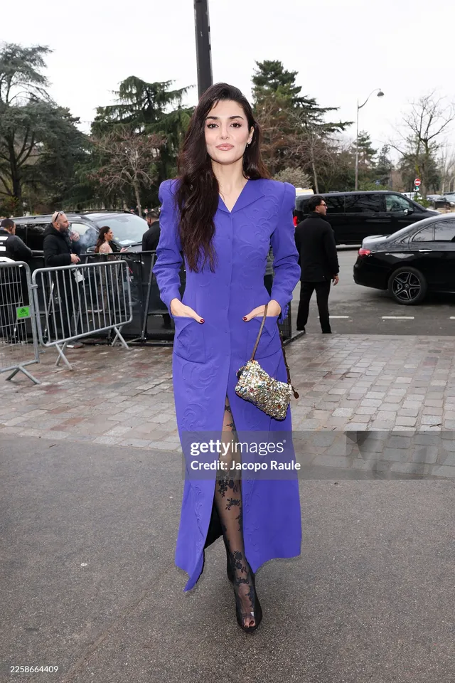 Hande Erçel wearing a purple coat dress and black heels.
