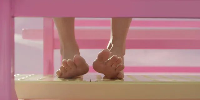 Margot Robbie: bare toes and soles raised on a pink step in Barbie.