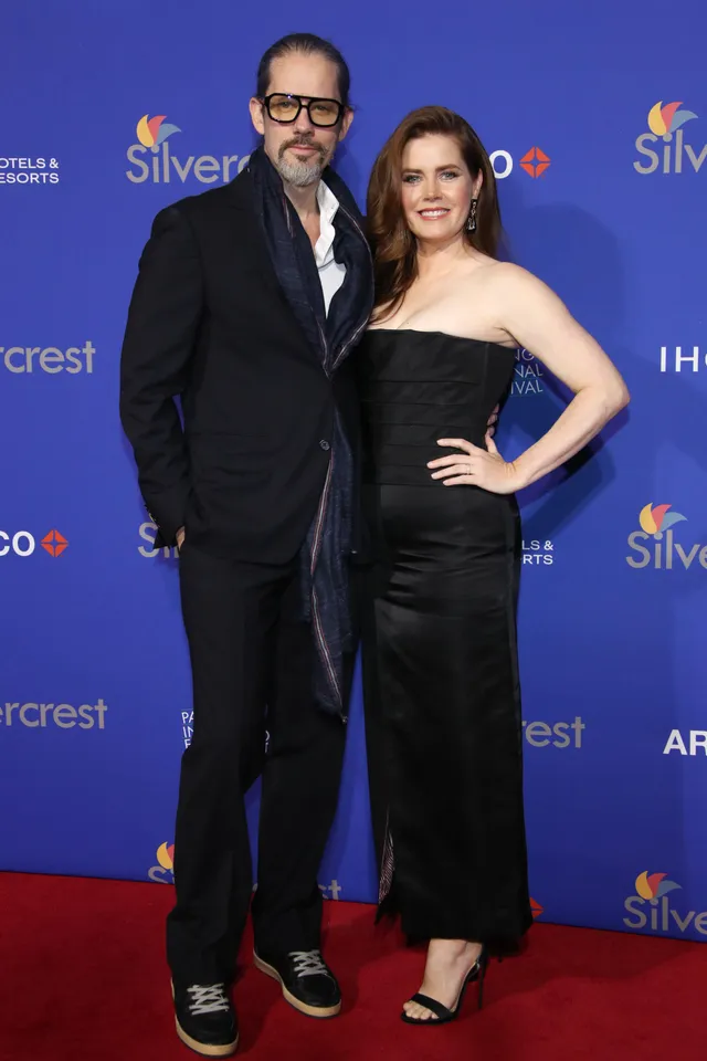 Amy Adams posing with a companion at an awards event.