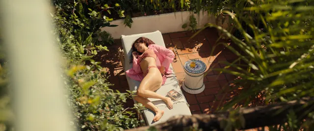 Olivia Cooke reclining on a garden lounger in a screen scene.