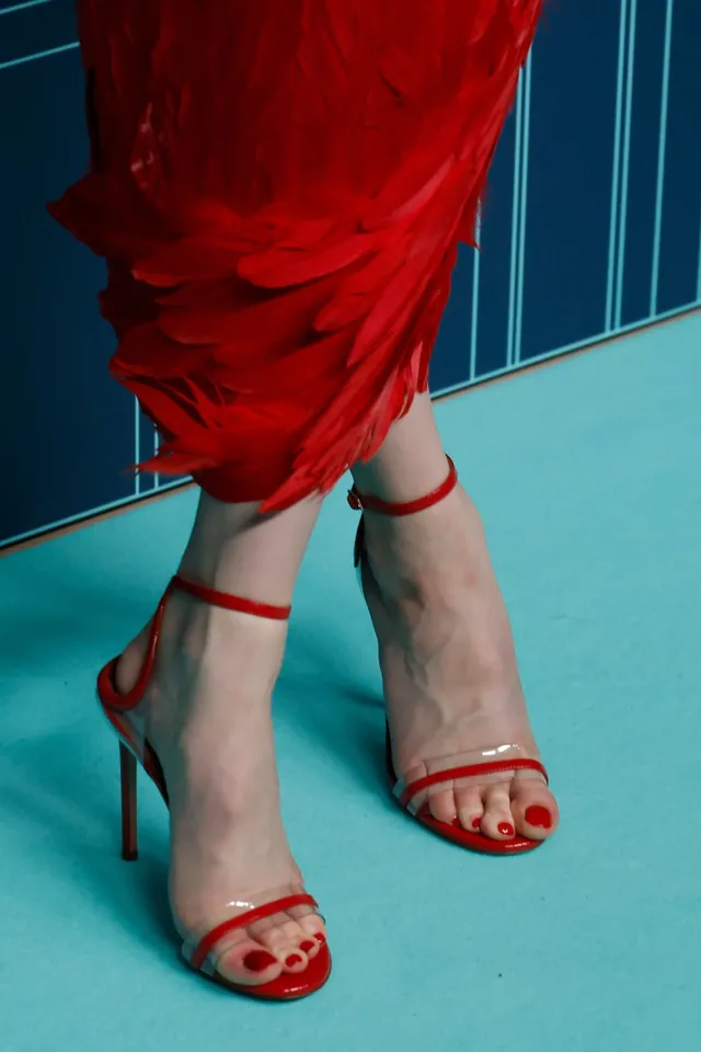 Anya Taylor-Joy wearing red strappy heels with a red outfit.