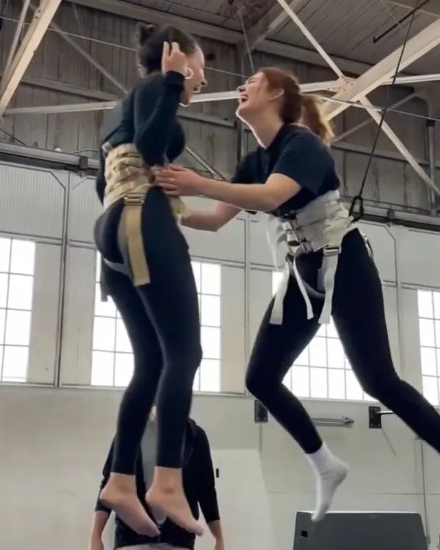 Dafne Keen practicing an aerial exercise in pale socks.