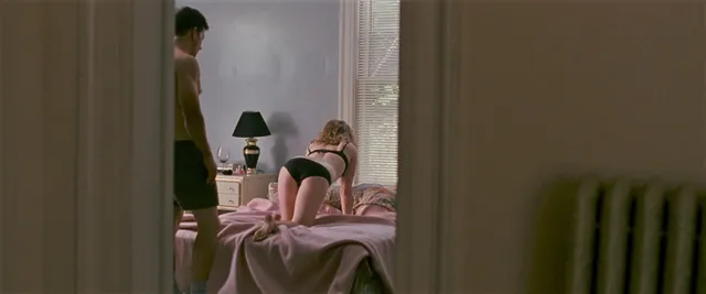 Amy Adams sitting on a bed during a screen scene.