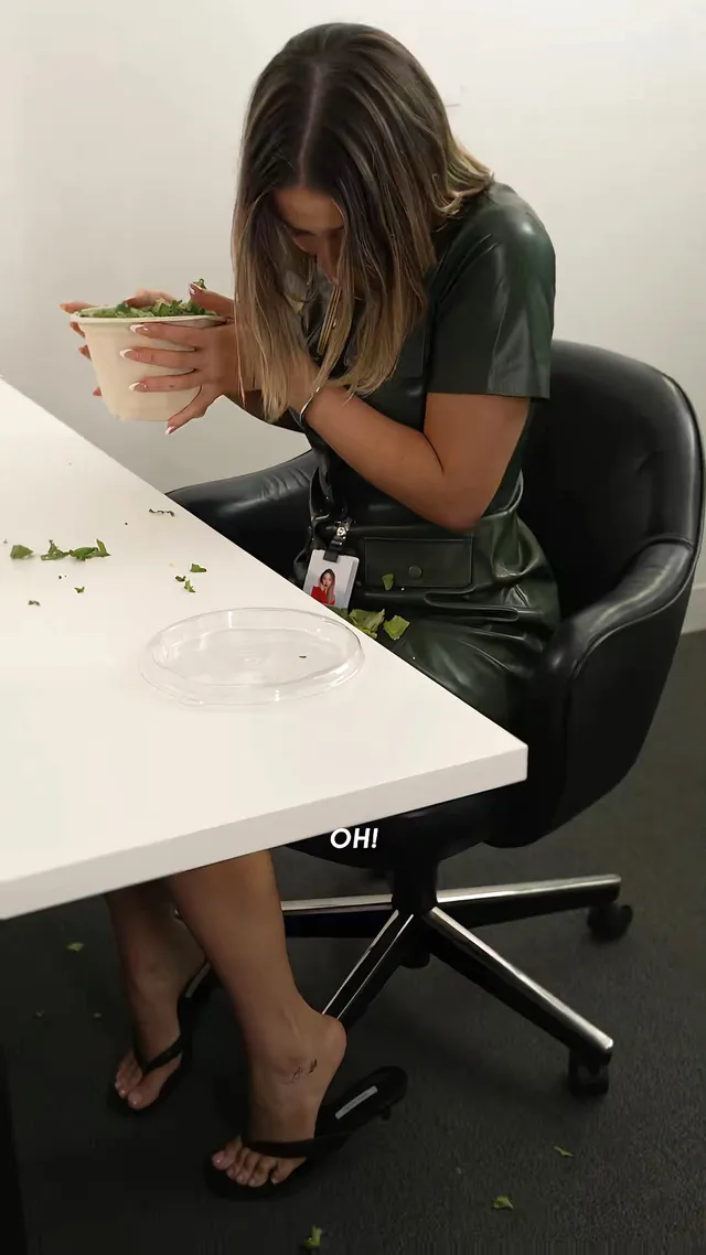 Madelyn Cline sitting at a table in a green outfit and flip-flops.