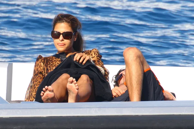 Eva Mendes reclining beside a companion on a boat.