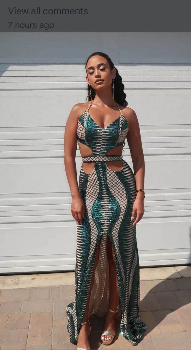 Emily Tosta wearing a green cut-out gown and clear heels.