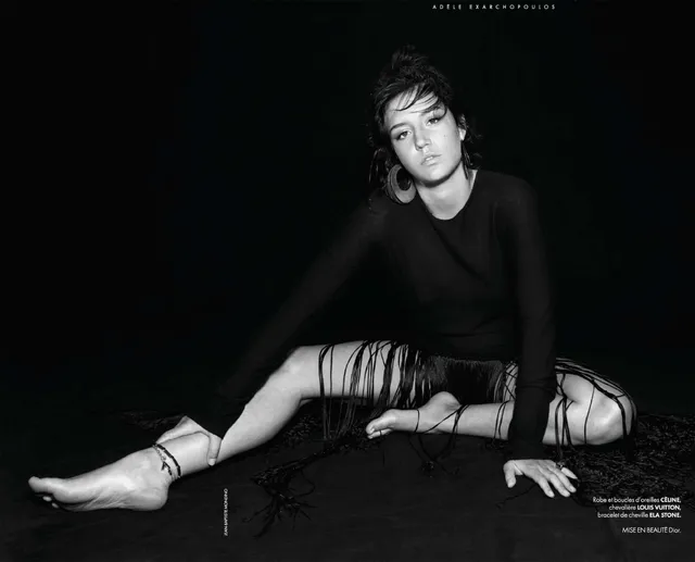 Adèle Exarchopoulos sitting on the floor in a monochrome fashion portrait.