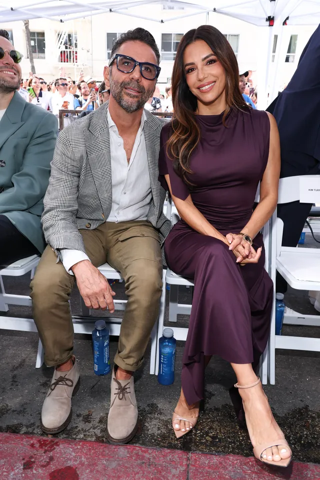 Eva Longoria posing with a man in a long purple dress.
