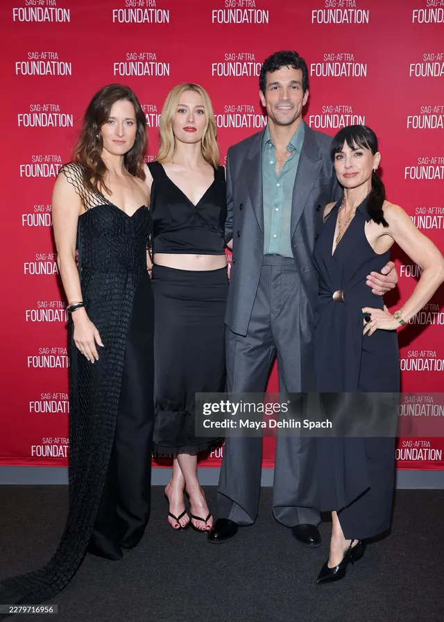 Sarah Pidgeon posing with fellow performers in a black outfit and flat sandals.